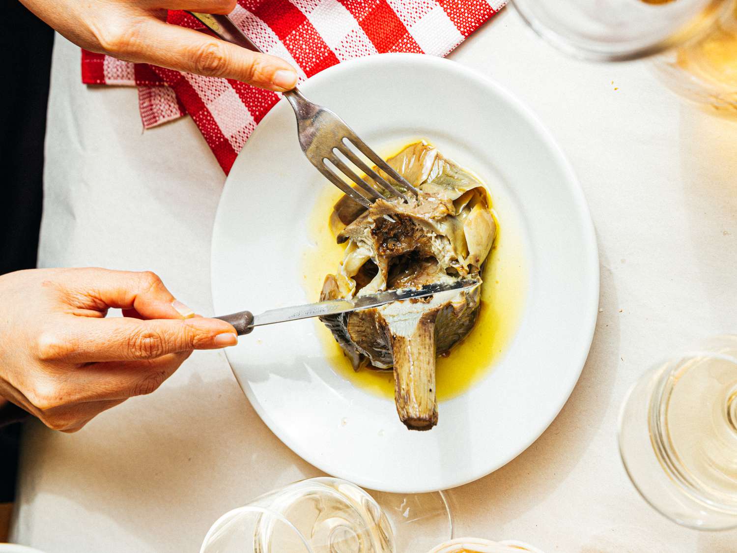 Overhead view of cutting into Carciofi alla Romana at Sora Margherita
