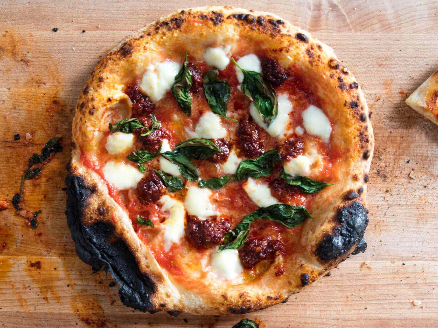 A pizza with 'nduja, topped with mozzarella and basil. 