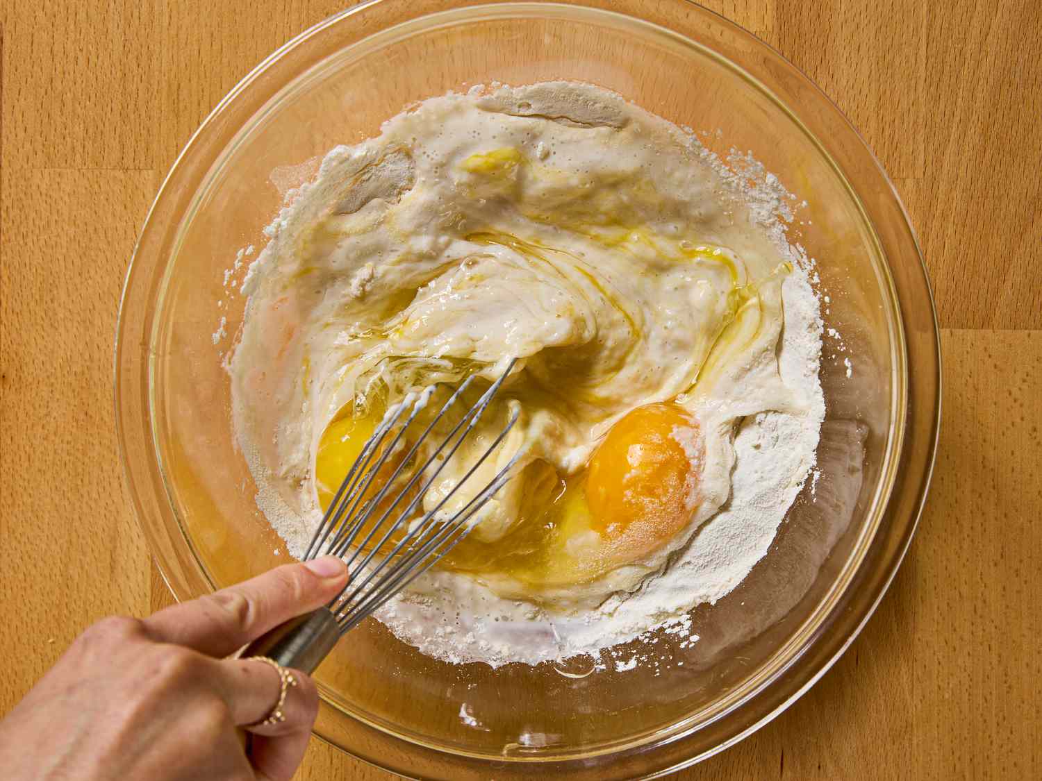 Whisking eggs and flour in a glass bowl