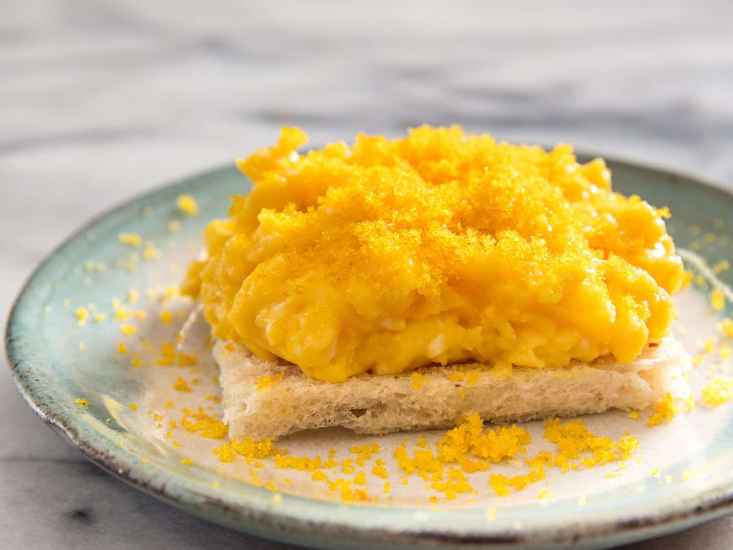 Soft scrambled eggs on toast topped with grated bottarga.