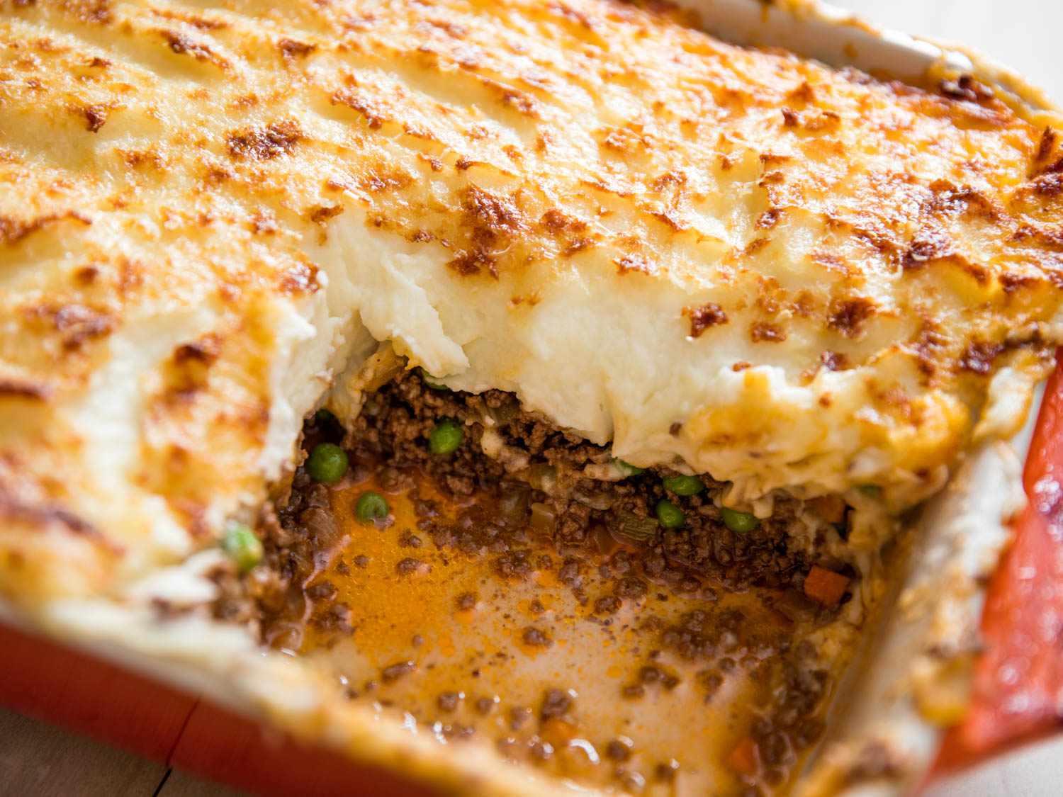 Shepherd's Pie in red casserole dish with one square portion removed