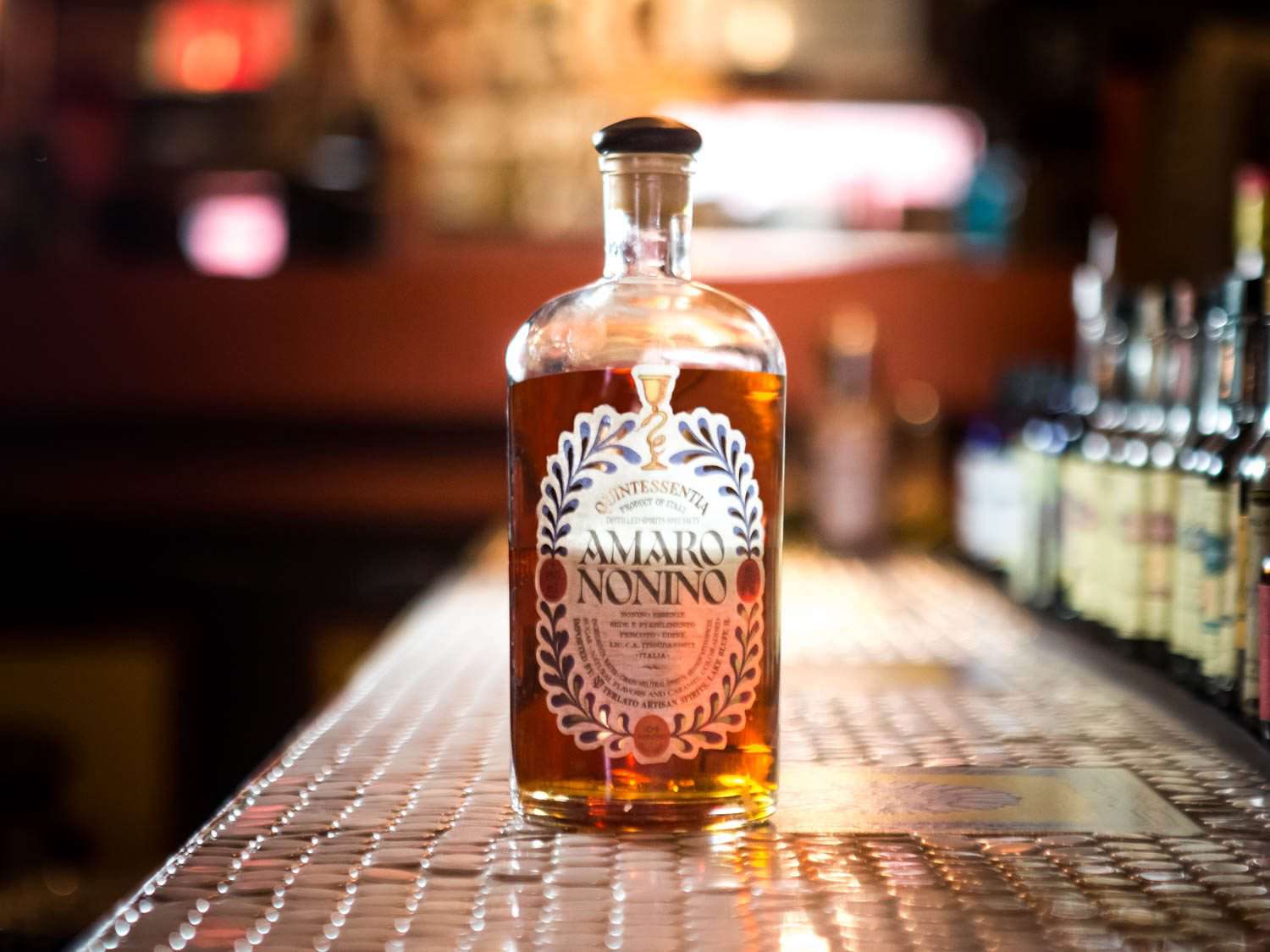 A bottle of Amaro Nonino Quintessentia on a bar counter.