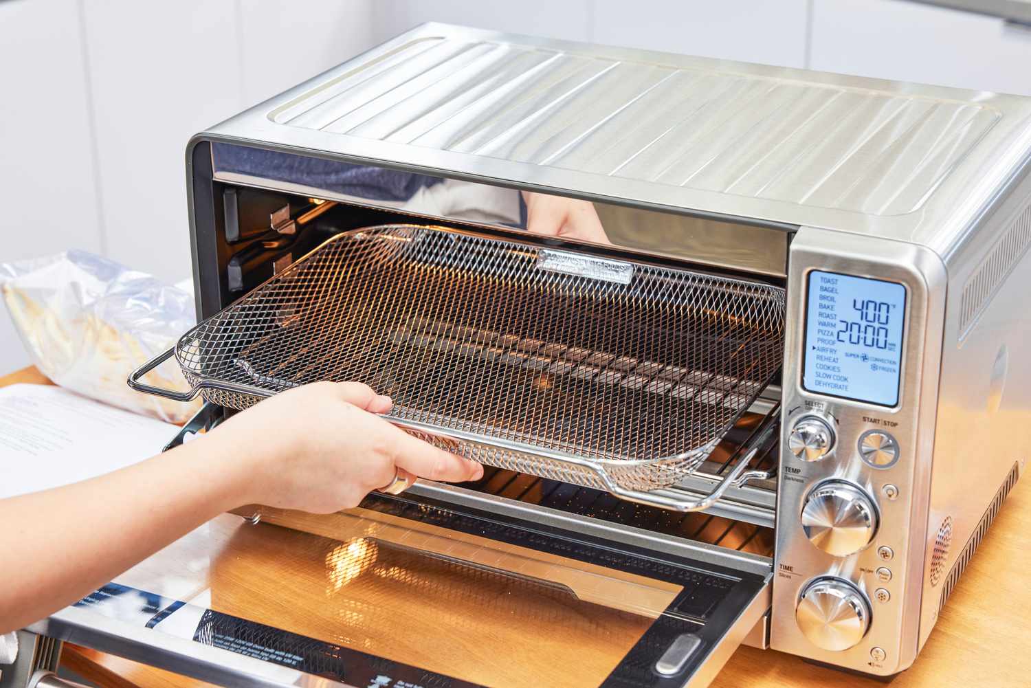 A hand holding a rack from the Breville the Smart Oven Air Fryer