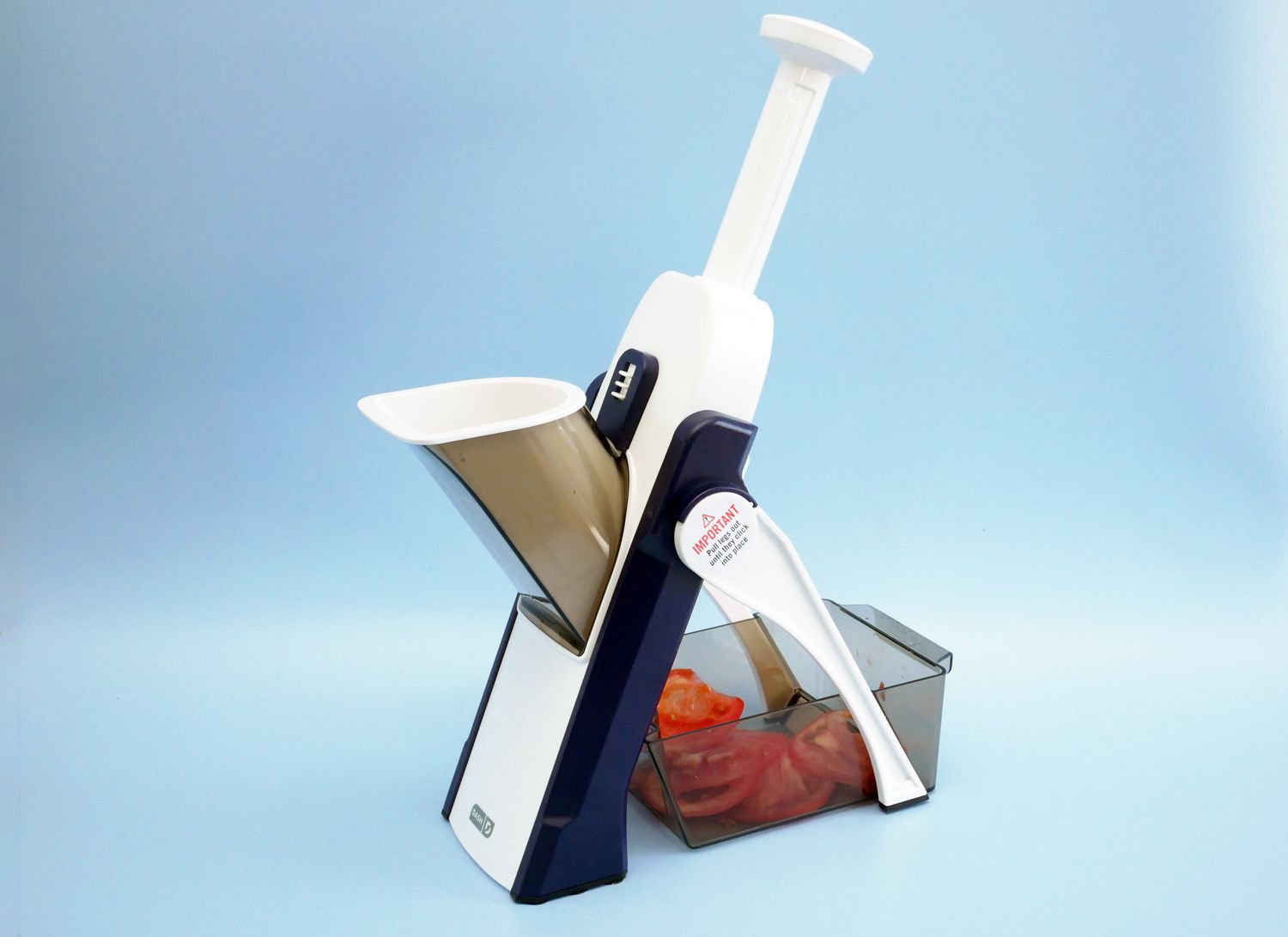 Dash mandoline slicer on a blue backdrop
