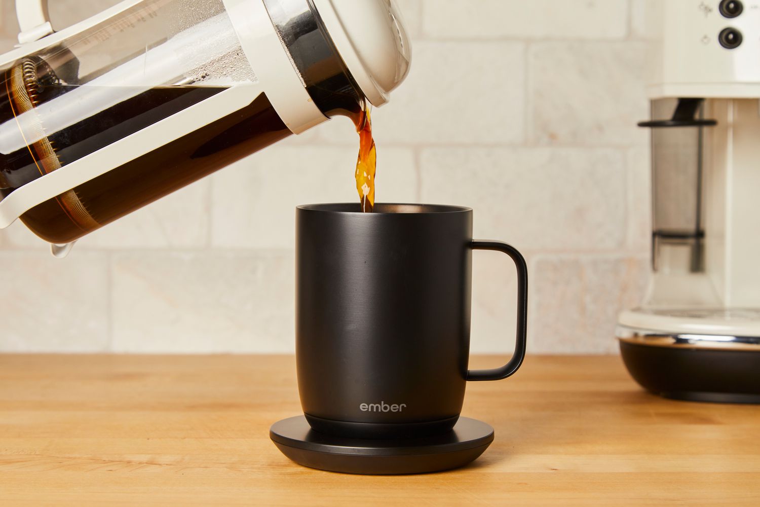 French press coffee being poured into an Ember Mug 2 on a charging pad