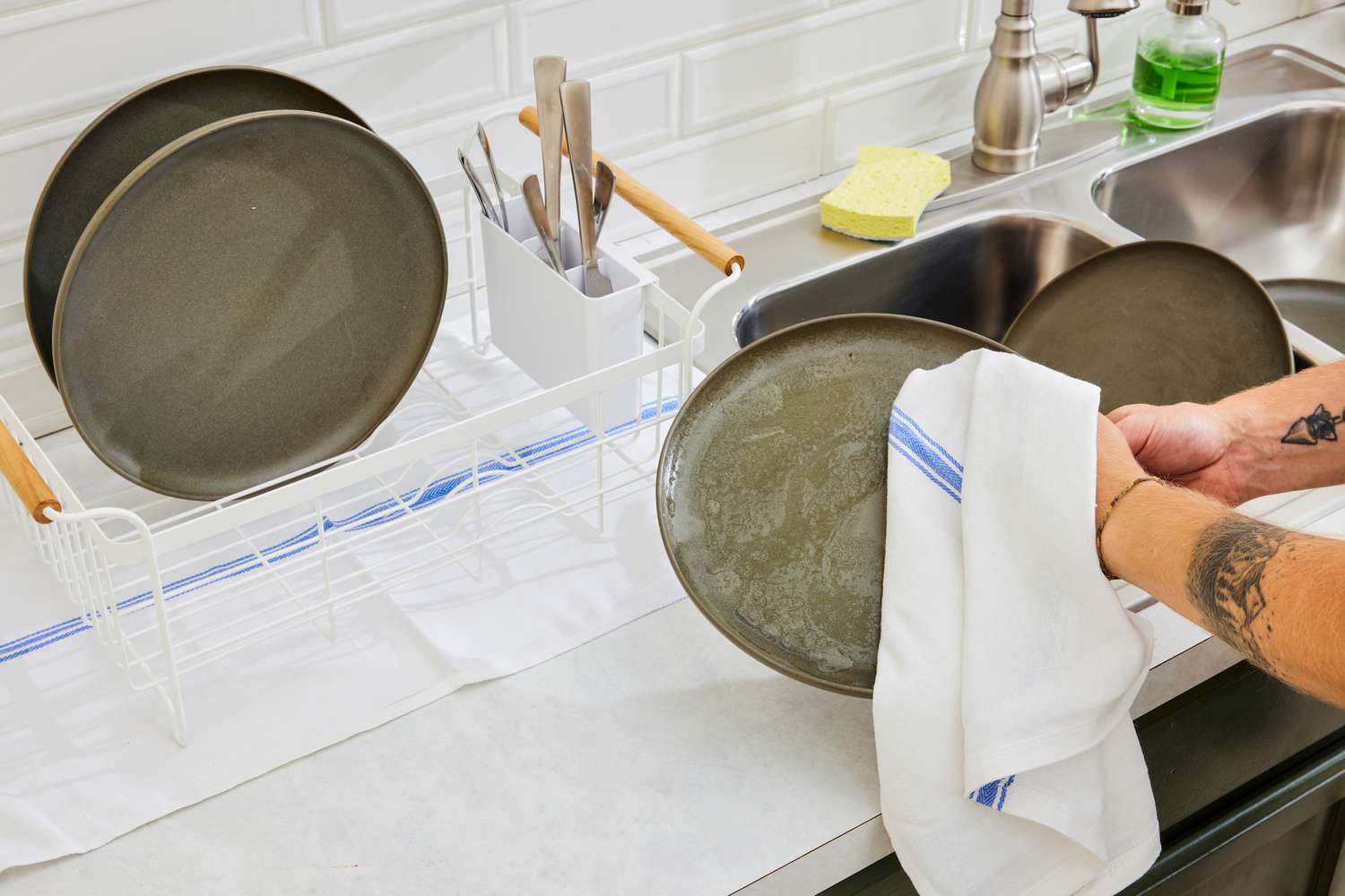 A person using the Zeppoli kitchen towel to dry a dish.