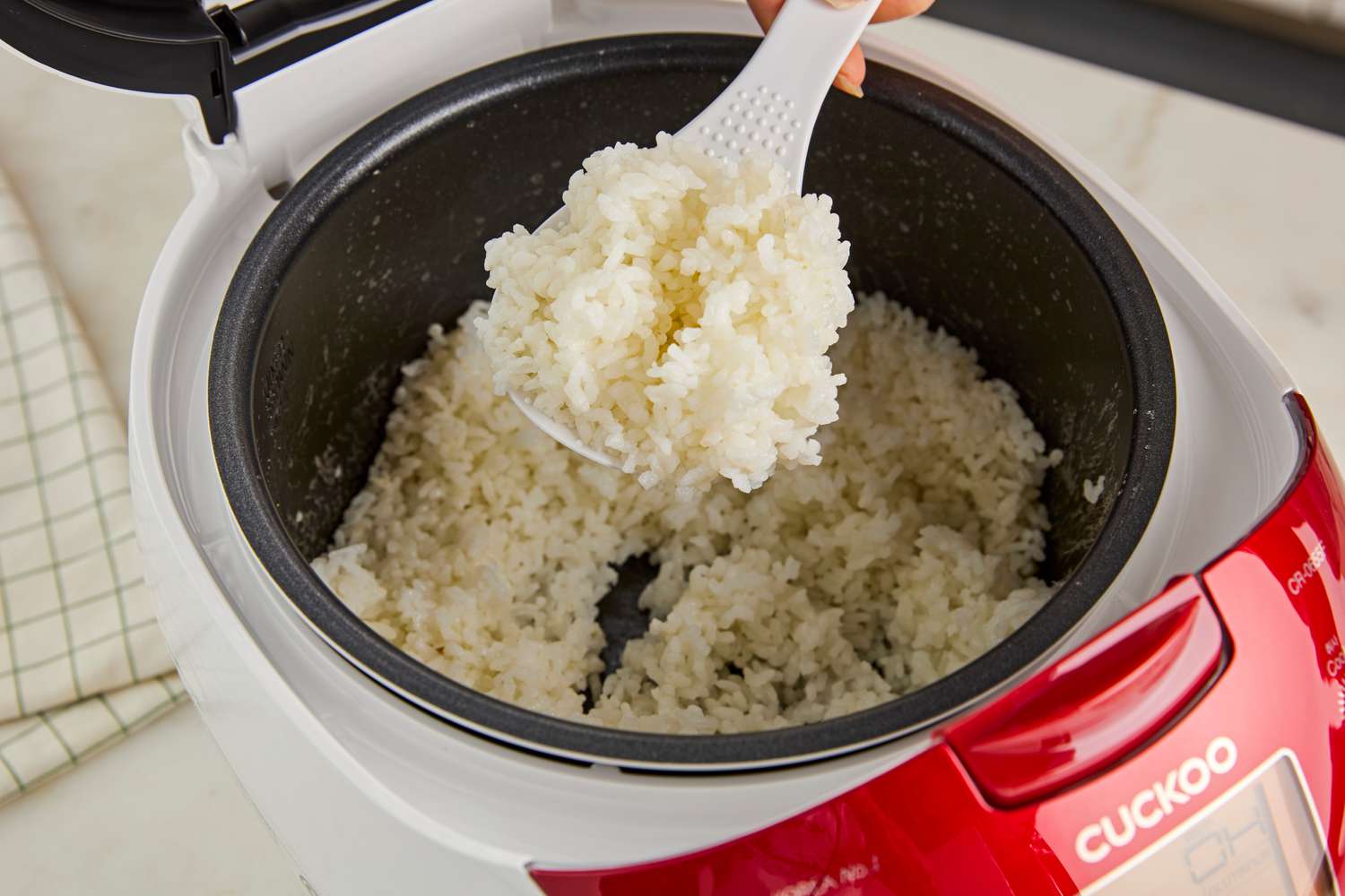 Rice being scooped out of the Cuckoo rice cooker.