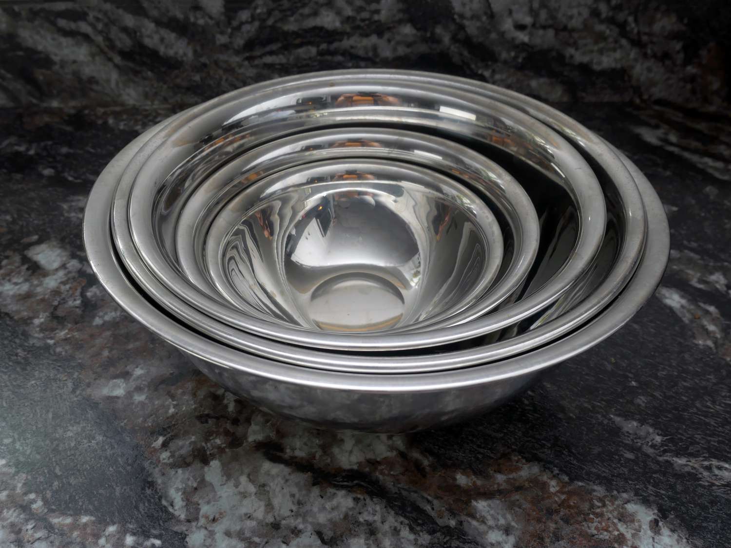 set of vollrath mixing bowls on a black marble countertop