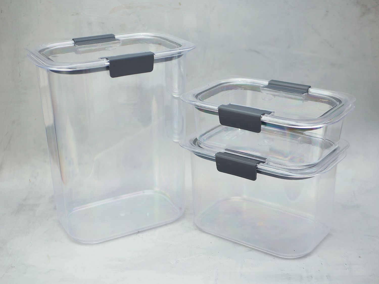 three rubbermaid containers on a gray surface