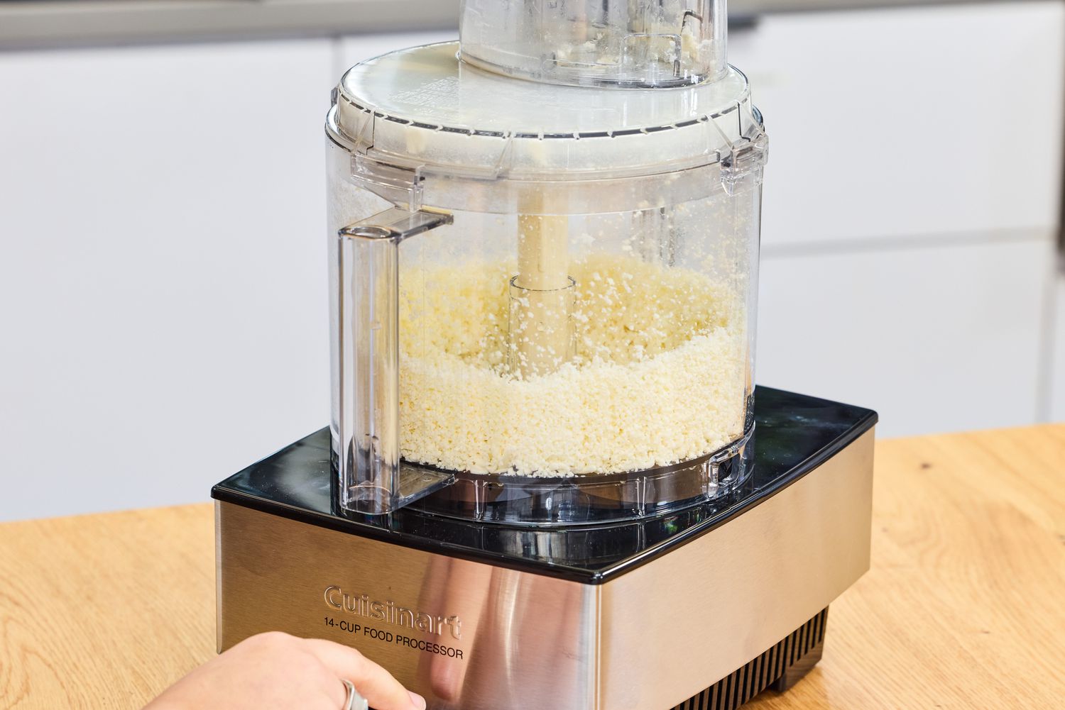 A person chops parmesan cheese in the Cuisinart 14-Cup Food Processor