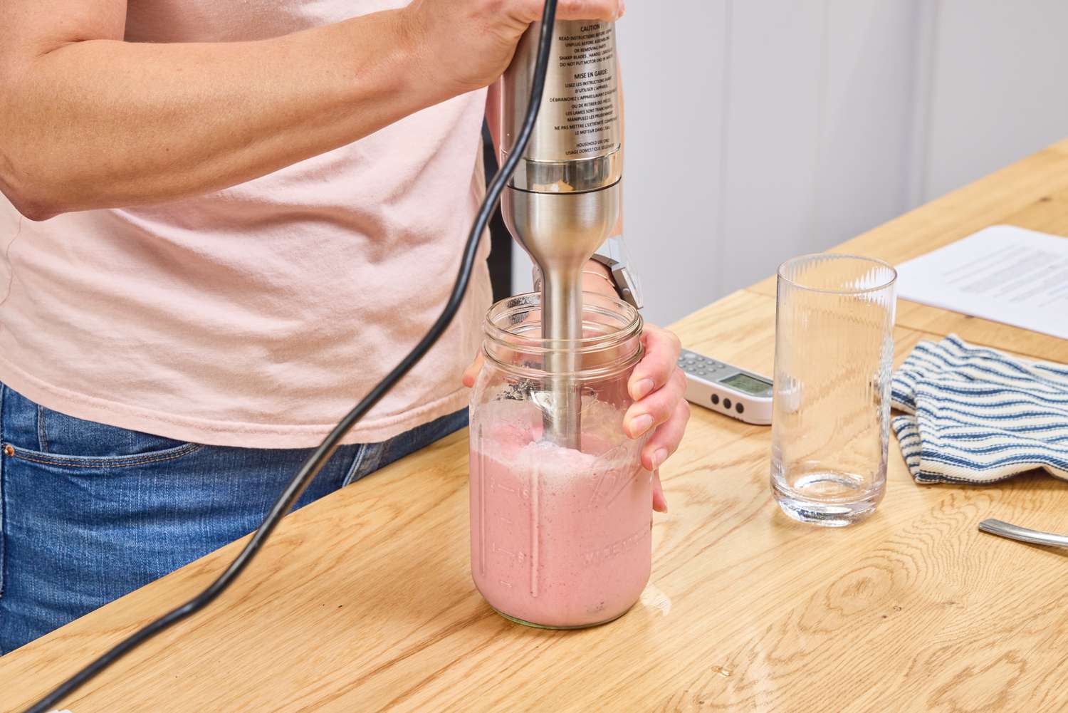 A person makes a smoothie using the Vitamix Immersion Blender