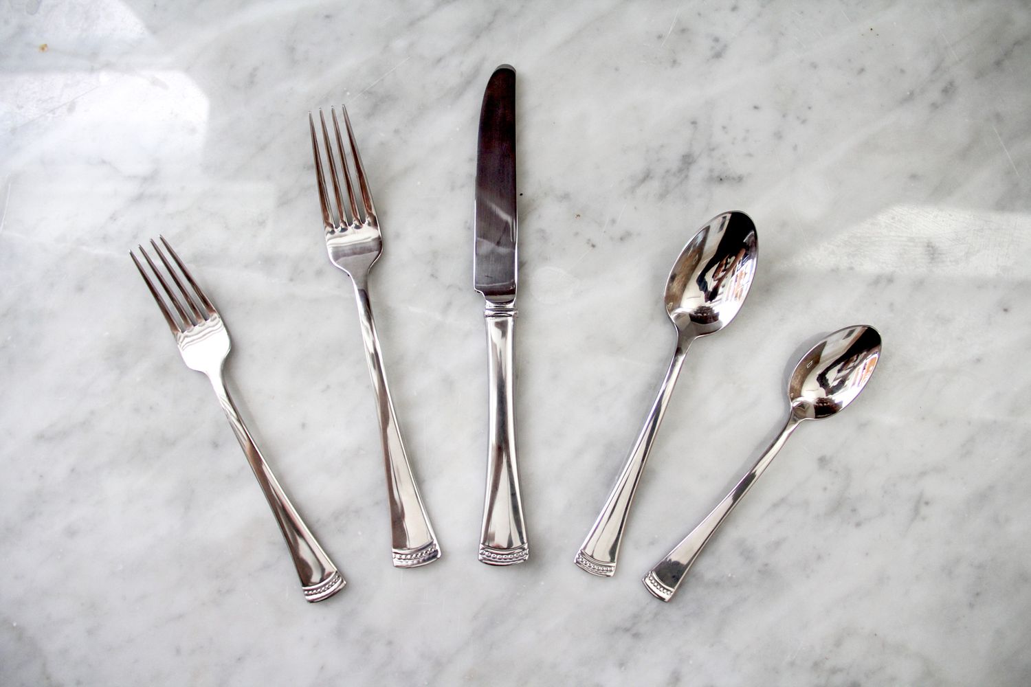 Various pieces of cutlery from the Lenox Portola 65-Piece Flatware Set