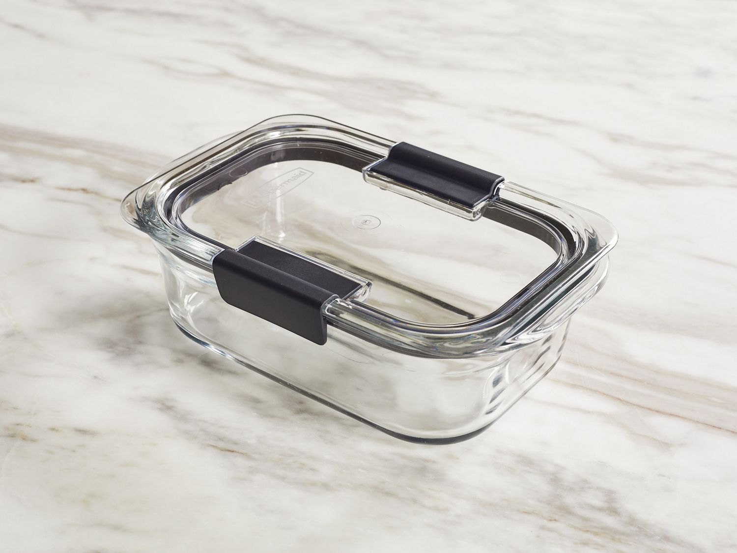 a glass food storage container sitting on a marble surface
