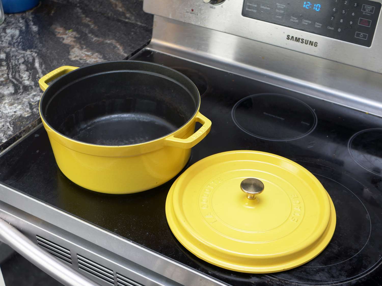 Staub Dutch oven on stove with lid off to the side