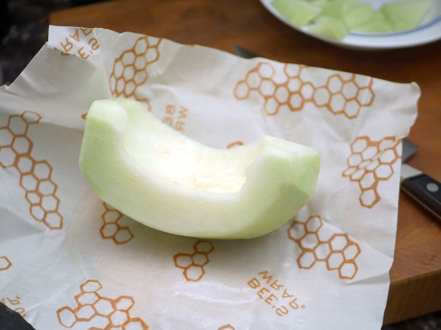 a slice of honeydew melon on top of a piece of beeswax wrap