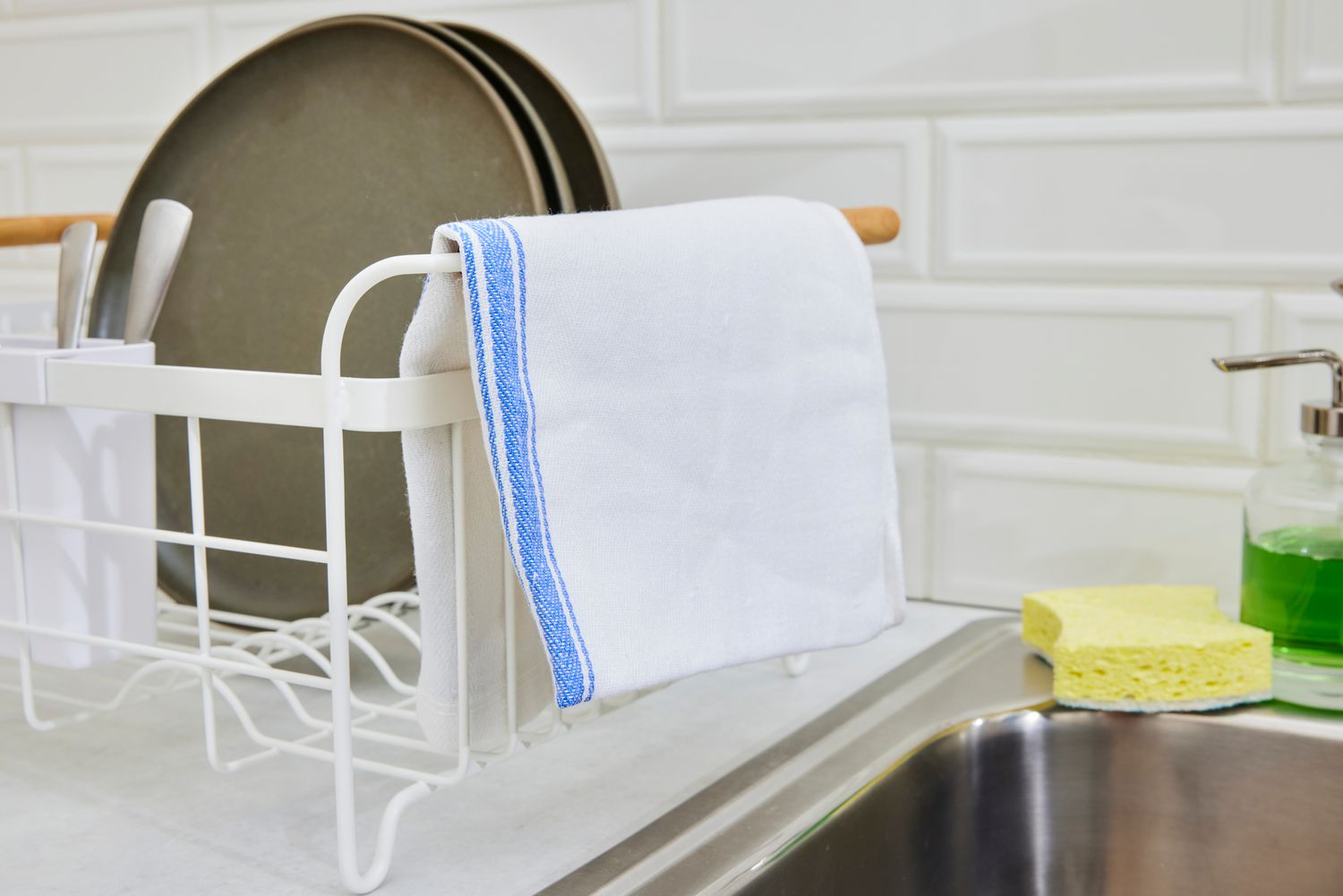 A Zeppoli kitchen towel hanging off of the side of a dish rack.
