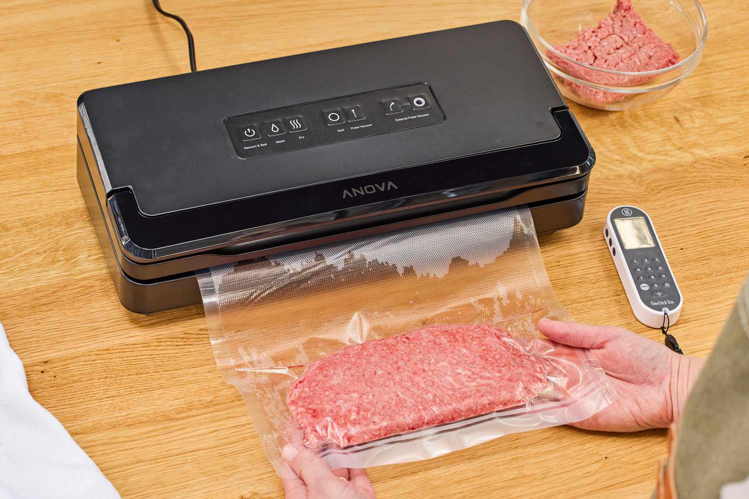 The Anova Precision Vacuum Sealer Pro is used to seal a bag of meat