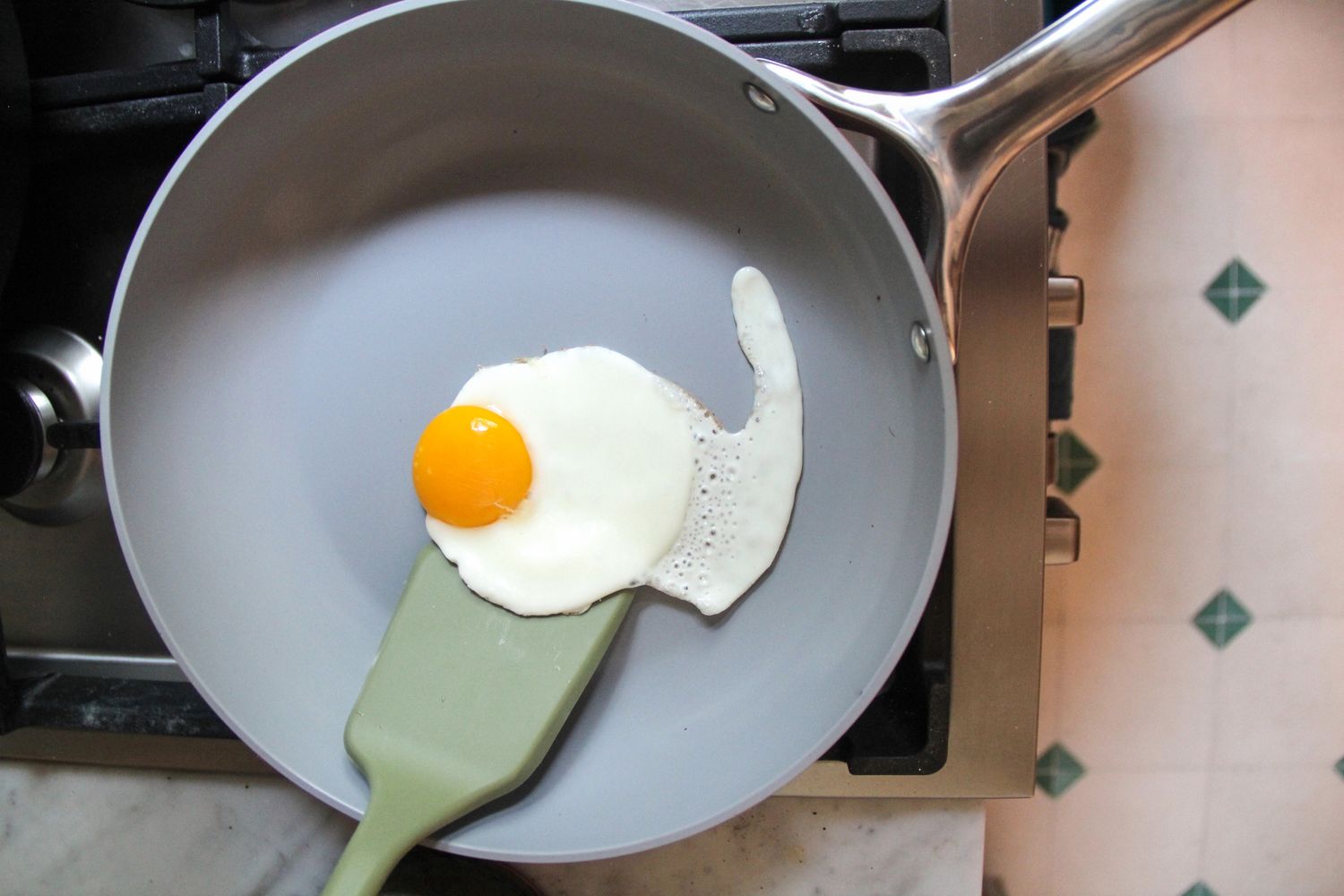 A spatula scooping an egg in the Caraway Nonstick Ceramic Frying Pan