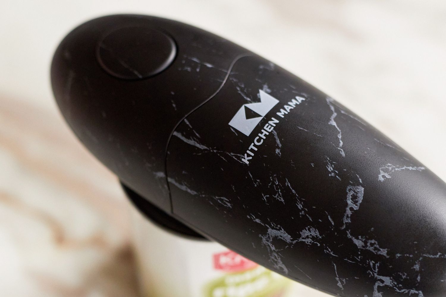 A close-up of a Kitchen Mama Electric Can Opener on a can