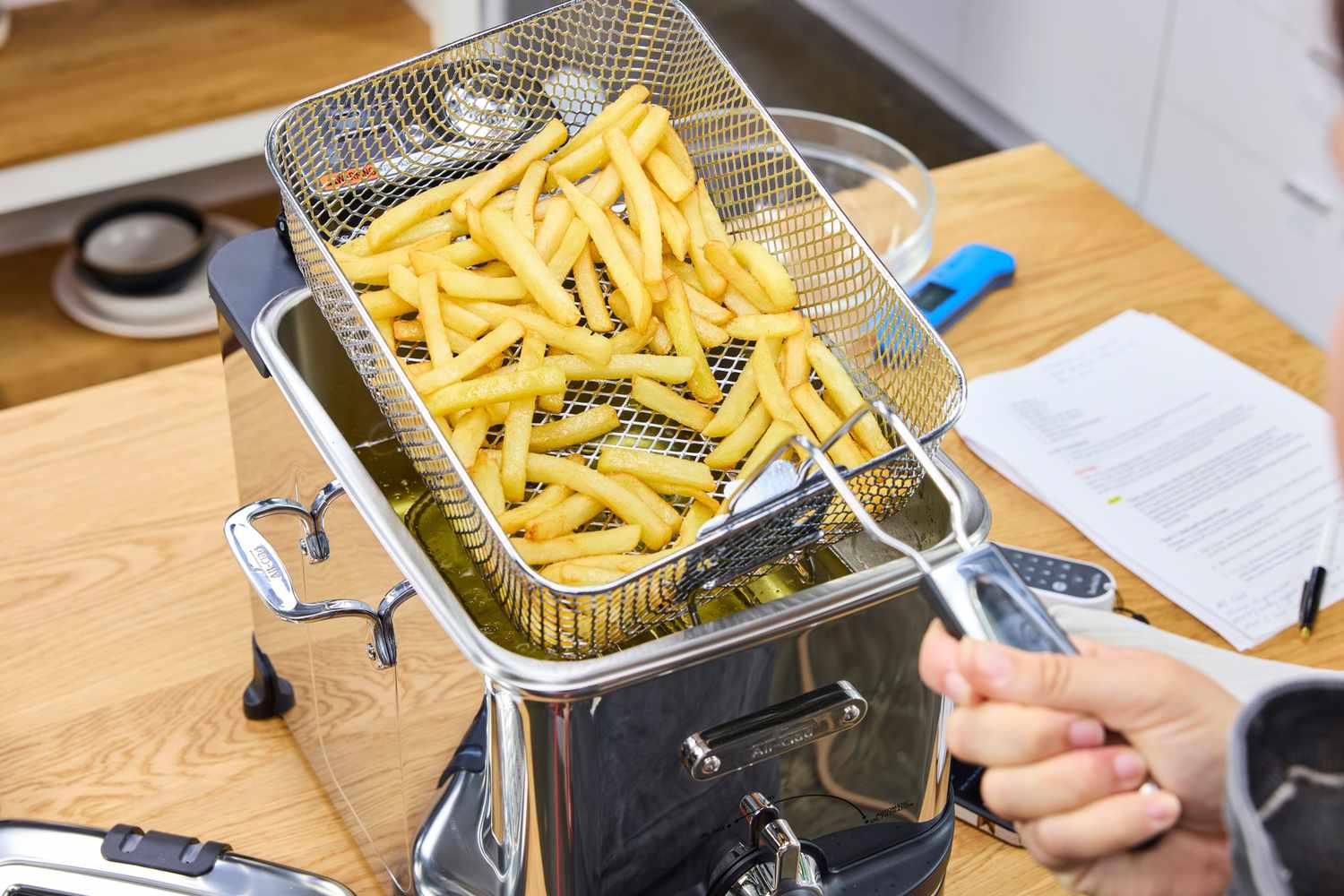 A basket filled with french fries made in the All-Clad Easy Clean Pro 3.5L Electric Deep Fryer