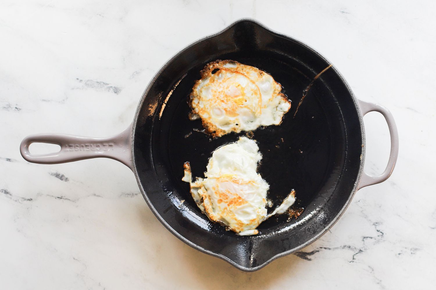 two over easy eggs in an enameled cast iron skillet