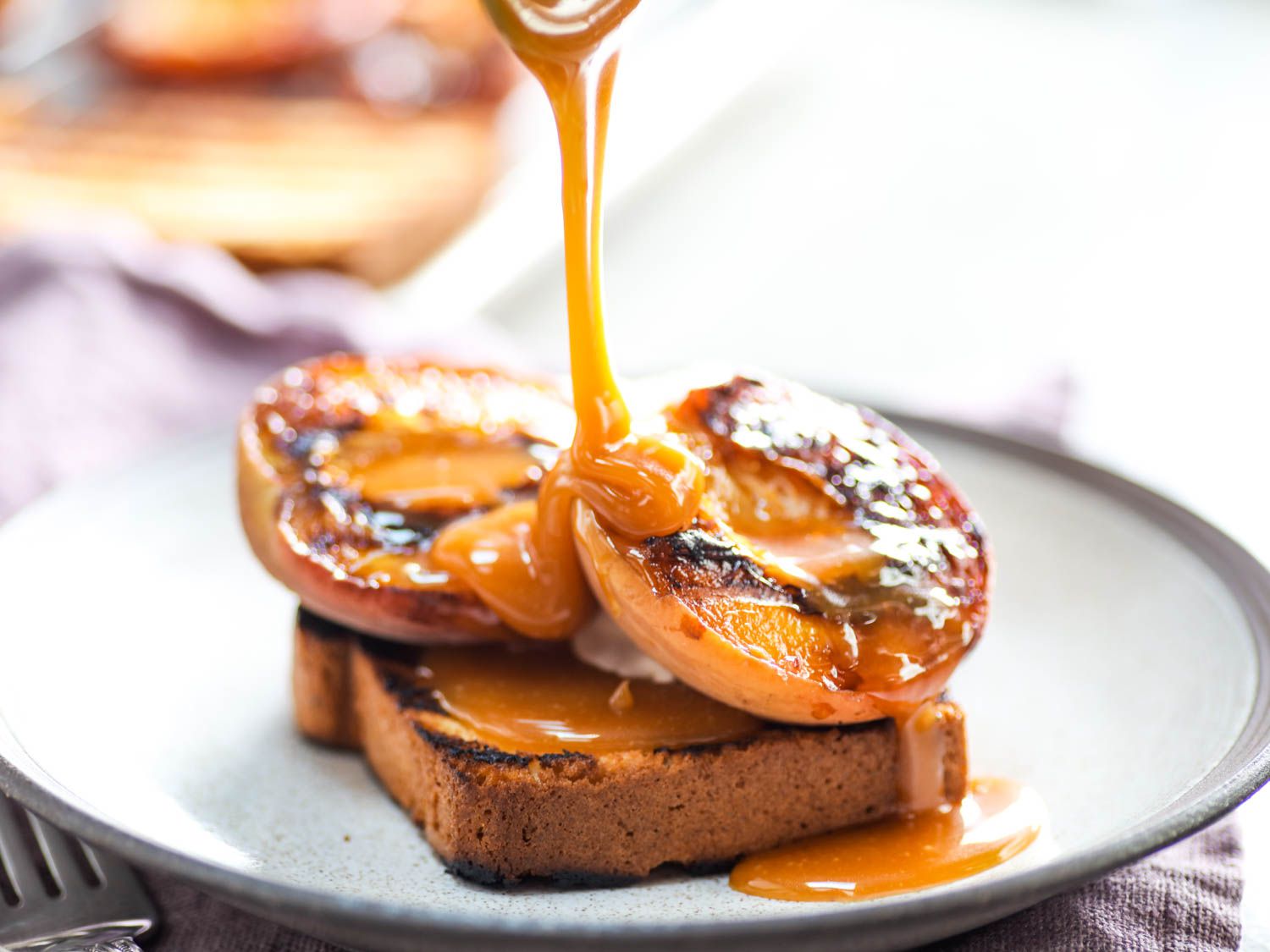 Grilled peaches with sauce poured on toasted pound cake