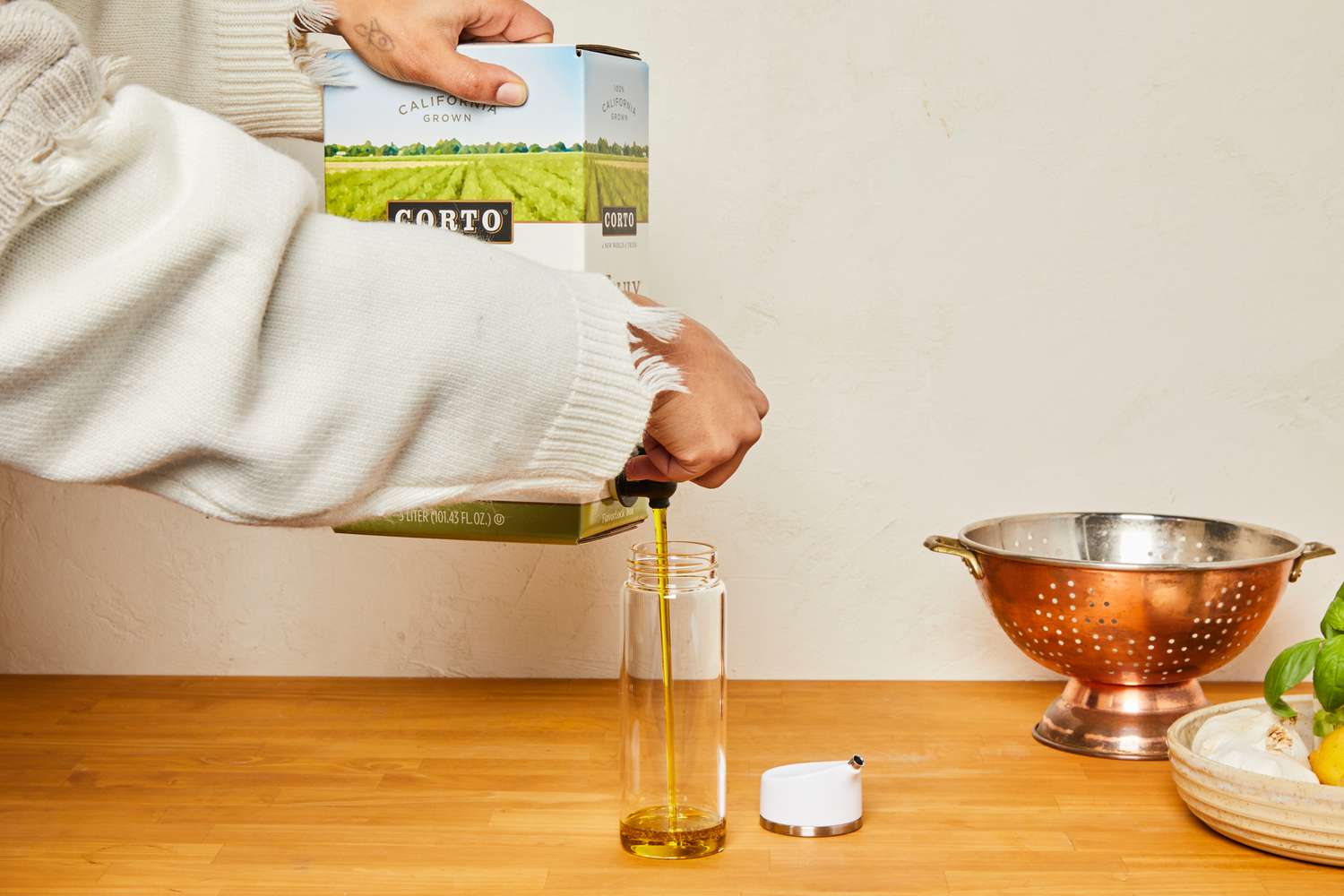 Corto olive oil being dispensed into an olive oil dispenser.